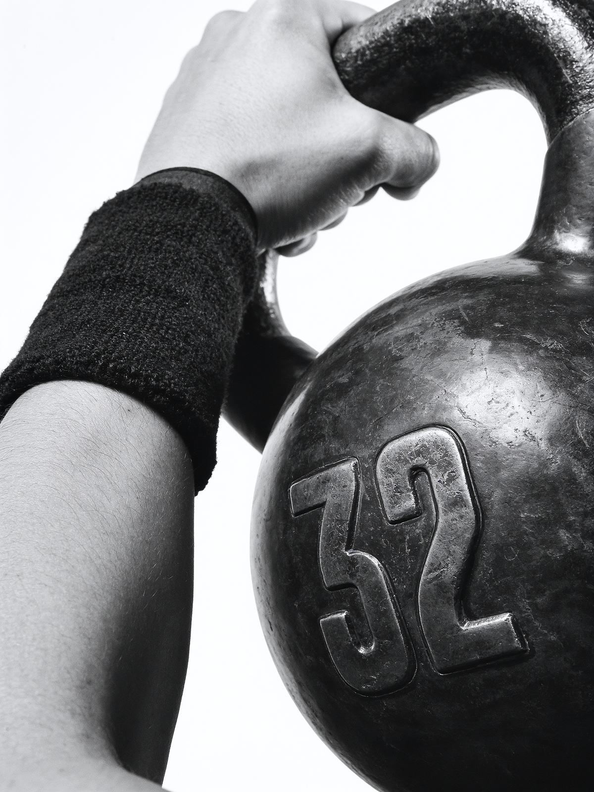 A hand holding a 32 kg kettlebell